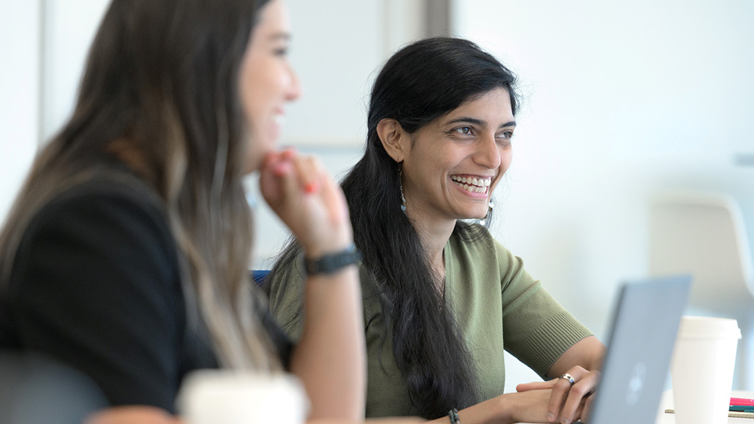 Female Oxy employee smiling at desk