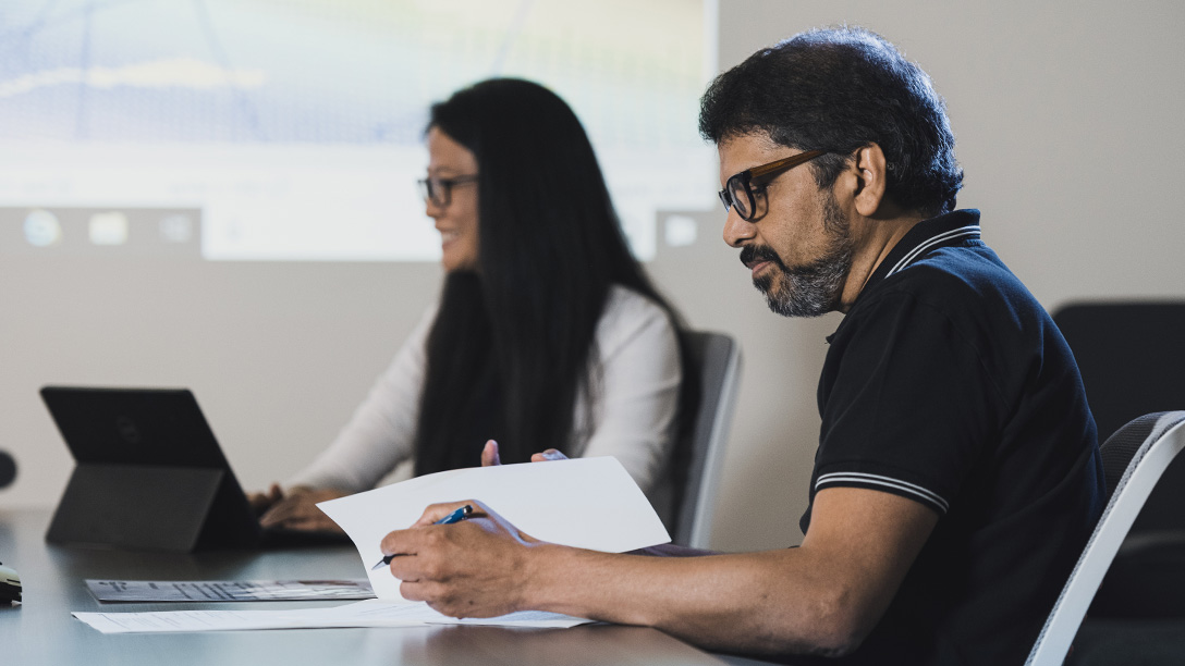 Male and female Oxy employees at conference room table