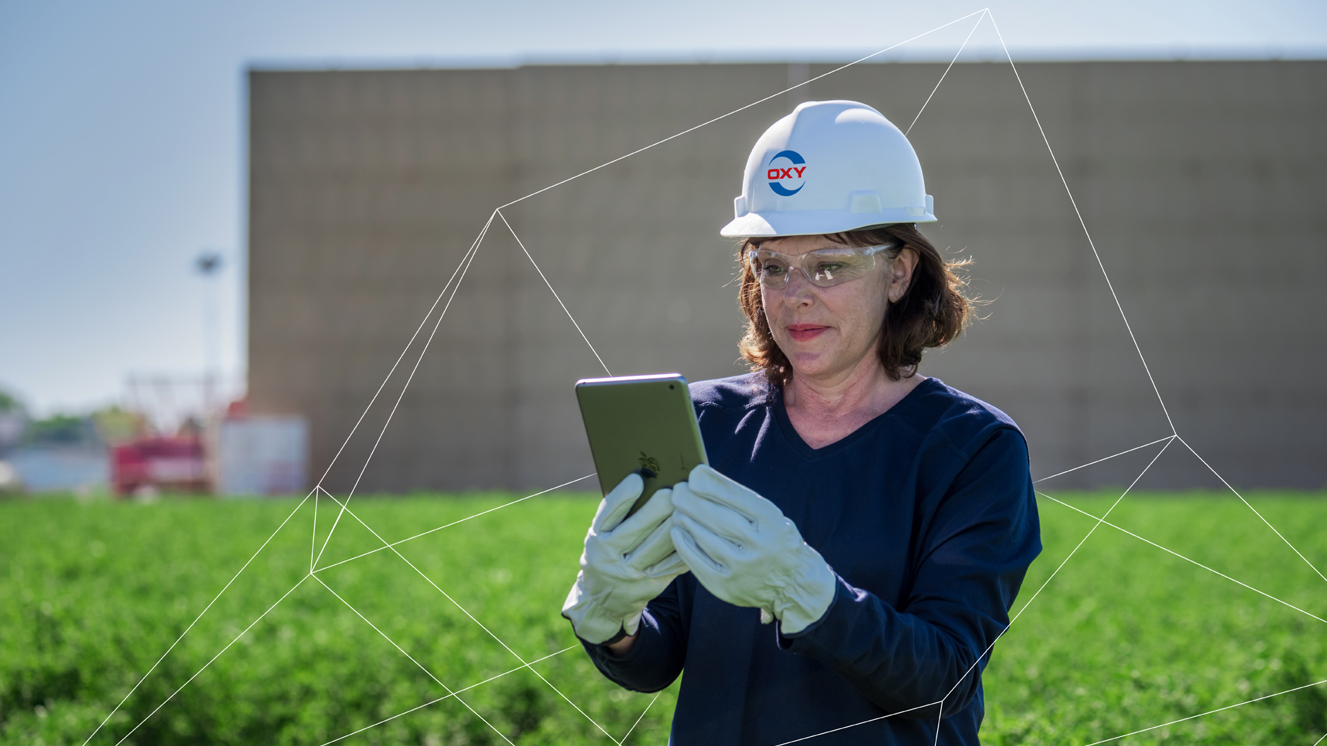 Female Oxy employee in green field holding iPad